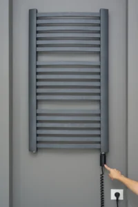 Ruka koja dodiruje grejač za radijator