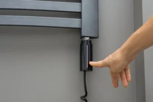 Osoba pokazuje prstom na električni sušač za kupatilo.