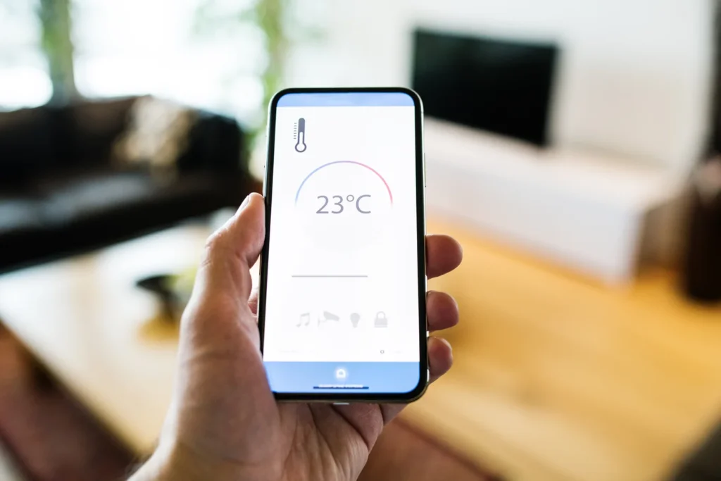 Zena drzi telefon sa otvorenom aplikacijom gde se vide koliko trose smart radijatori